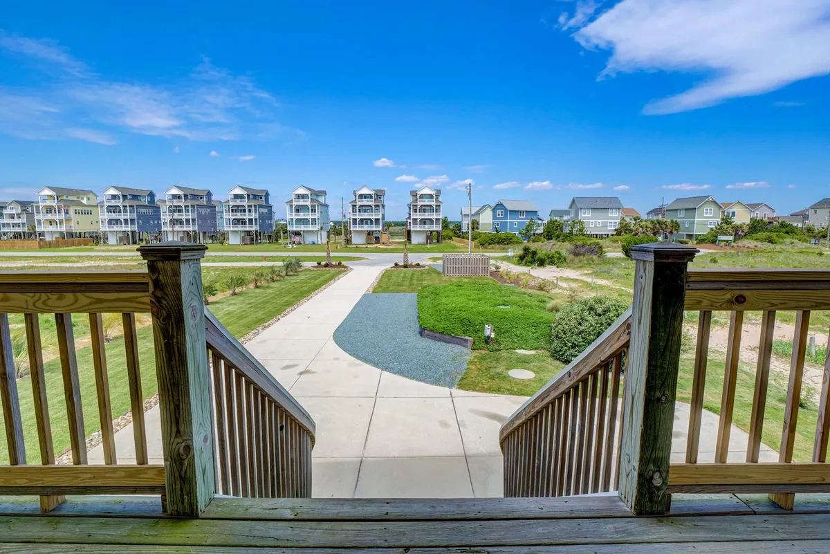 This exterior image features a landscaped yard with a visible pathway leading out, framed by neighboring homes and greenery. It evokes the idea of neighborhood exploration, morning walks, and a safe, pleasant environment for families and dogs.